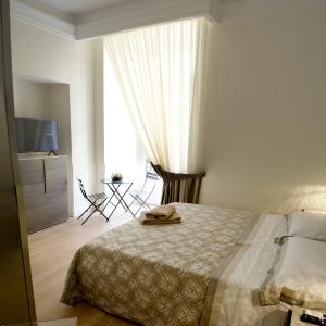 那不勒斯fafgrandsuitenapoli的一间卧室配有一张床、一个梳妆台和一扇窗户。