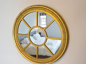 布里奇诺斯Woodberry Inn的墙上的金色镜子,床上