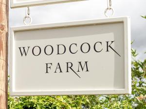 布里斯托Woodcock Farm的挂在建筑物上的木鸡场的标志