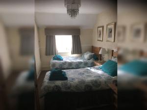 艾恩布里奇Ye Olde Robin Hood Inn的一间卧室设有两张床和窗户。