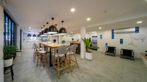 拉廊Blu Monkey Hub & Hotel Ranong的用餐室以及带桌椅的厨房。