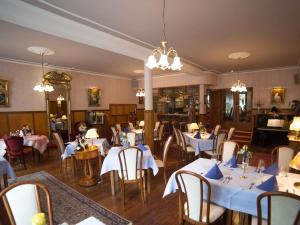 Burg (an der Mosel)祖尔波斯特酒店 - 摩泽尔河畔城堡的一间设有白色桌椅的用餐室