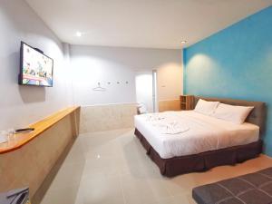 梭桃邑ลิตเติ้ล ฮิลล์ สัตหีบ รีสอร์ท ( Little Hill Sattahip Resort )的一间酒店客房,配有一张床和一台电视