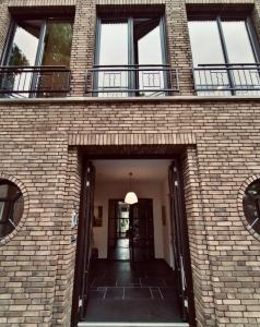 多德雷赫特Arthouse Dordrecht的砖砌建筑,设有窗户和走廊