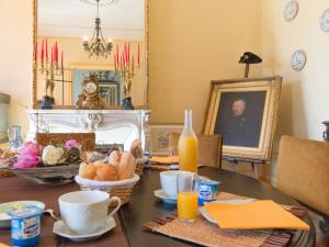 Bonnac-la-Côte圣安托尼城堡酒店的用餐室配有带面包和橙汁的桌子