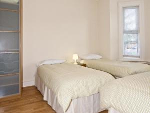 亨顿Chumleigh Lodge Hotel Ltd.的白色墙壁客房的两张床