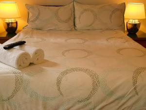 亨顿Chumleigh Lodge Hotel Ltd.的一张带两条毛巾的床和遥控器