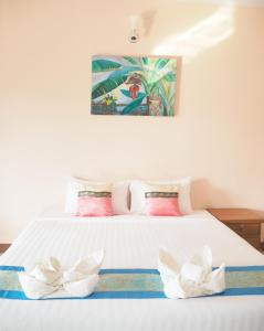 Ban Lai Ngao康柯丽德度假酒店的一张白色的床,上面有两朵白色的花