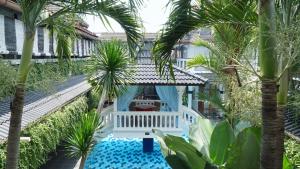 日惹雨树精品别墅及画廊旅馆的享有棕榈树和游泳池度假村的空中景致