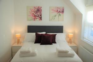 南安普敦Coach House的一间卧室配有一张带两盏灯的大型白色床。