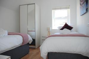 南安普敦Coach House的一间卧室设有两张床和窗户。