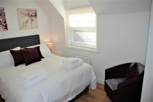 南安普敦Coach House的卧室配有白色的床和椅子