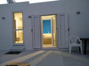 帕拉斯波罗斯SOUVLIA BEACH的白色的房子,配有椅子和窗户