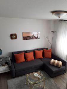 黑尔戈兰岛Ferienwohnung Hummer im Haus Daheim的客厅配有蓝色长沙发及橙色枕头