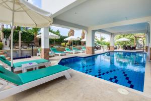 利迈纳里亚戈尔登公寓式酒店的一个带椅子和遮阳伞的游泳池
