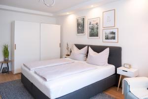 格拉茨MH Living - 5 - Scandinavian Living Dream in Center的白色卧室配有一张带白色枕头的大床