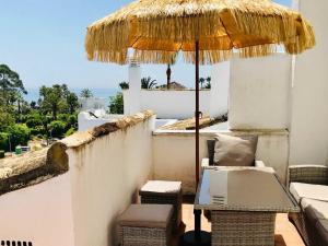 EsteponaStunning Penthouse Just Footsteps Away from Estepona's Beaches的庭院配有遮阳伞和桌椅。