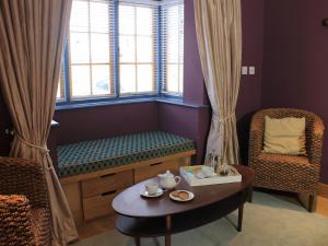 Hemingford GreyThe Lodge at Hemingford Grey House的一间带长凳、桌子和窗户的房间