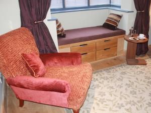 Hemingford GreyThe Lodge at Hemingford Grey House的客厅配有椅子和长凳