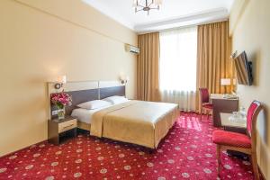 基辅乌克兰酒店的酒店客房,配有床铺和红地毯