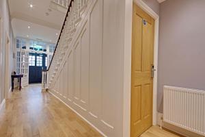 利明顿Highfield Bed & Breakfast的走廊设有白色墙壁和木楼梯