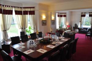 霍利Hookwood Lodge的一间带桌椅的用餐室和一间带沙发的房间