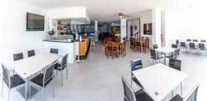 拉科萨诺迪鲁斯酒店的厨房以及带白色桌椅的用餐室。