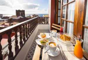 圣克鲁斯-德拉帕尔马El Hotelito 27的阳台上的桌子上摆放着食物和咖啡