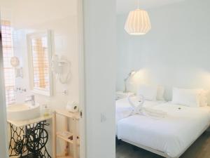 圣克鲁斯-德拉帕尔马El Hotelito 27的白色卧室设有水槽和一张床