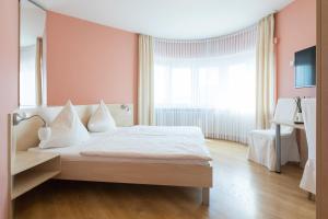 拉恩河畔林堡马汀酒店的卧室设有白色的床和大窗户