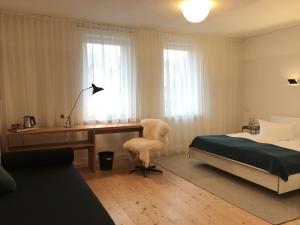 哈茨山区黑尔茨贝格海泽尔酒店的一间卧室配有书桌、一张床、一张桌子和椅子