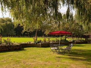 牛津Cherbridge Lodges - Riverside lodges, short lets (business or holidays)的公园里红色伞下的桌椅