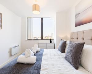 伯明翰KCS Luxury Apartment - Broad Street Birmingham的卧室设有一张大白色的床和大窗户