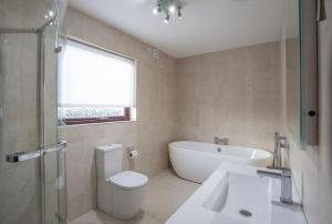 克拉姆林吉福汉娜乡村别墅酒店的浴室配有卫生间、浴缸和水槽。