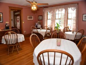 盖茨堡Keystone Inn Bed and Breakfast的一间设有白色桌椅的用餐室