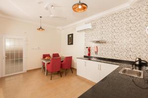 Al RuwisAl Asala Resort的一间厨房,内设红色椅子和桌子