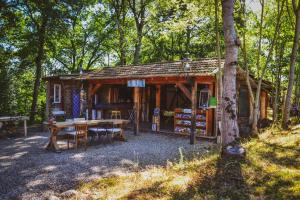 EscosseChalets & Camping Villa Mayari的树林中的一个小小屋,配有桌椅