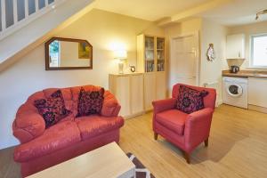 哈罗盖特Host & Stay - The Limes的客厅配有红色的沙发和椅子