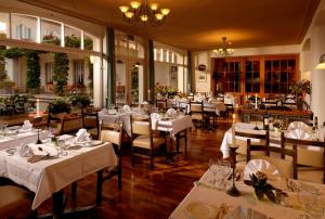 因特拉肯美地酒店的一间设有白色桌椅的用餐室