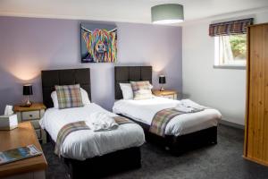 MacduffThe Knowes Hotel & Restaurant的一间卧室设有两张床,墙上挂着一幅画