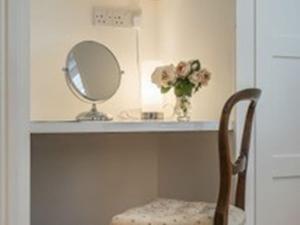塞文欧克斯Knole B&B的一个带镜子的柜台和一把椅子