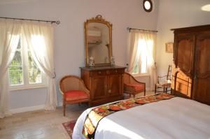 洛尔格La Bastide des Enquèses的卧室配有床、镜子和椅子