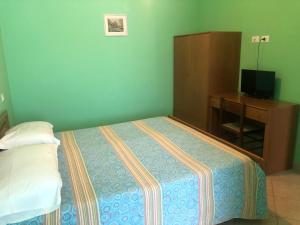 拉奎拉Il Portichetto的一间卧室配有一张床、一个橱柜和一台电视