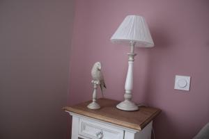 MardeuilLA PART DES ANGES的鸟雕像坐在台灯旁边的桌子上
