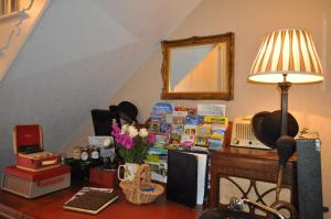 布兰德福德福鲁姆Lower Bryanston Farm的杂乱的房间,配有一张桌子、一盏灯和书籍