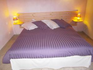 Saint-André-en-Vivarais乐派切德帕赛旅馆的卧室里一张大紫色的床,配有两盏灯