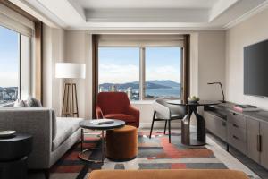 旧金山Four Seasons Hotel San Francisco at Embarcadero的带沙发和椅子的客厅以及大窗户。