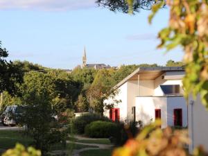 巴登Gîtes & Tiny houses Les Hauts de Toulvern的院子里有红色门的白色房子