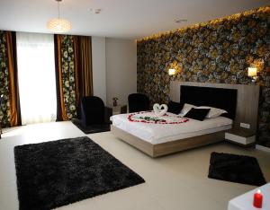 克拉约瓦MELISS EVENTS的一间卧室配有一张大床和两把椅子