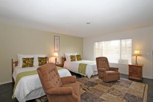 沙漠温泉丽都棕榈度假Spa酒店的一间卧室配有两张床和椅子
